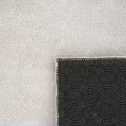 Tapis doux et lavable avec envers antidérapant, disponible en couleurs unies.