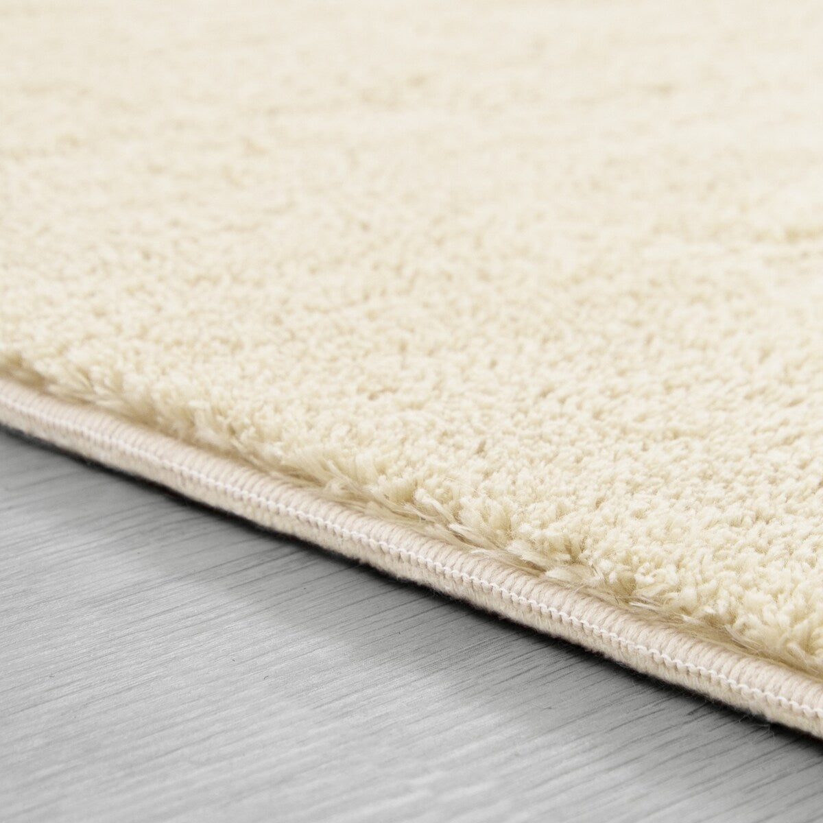 Tapis doux et lavable avec envers antidérapant, disponible en couleurs unies.