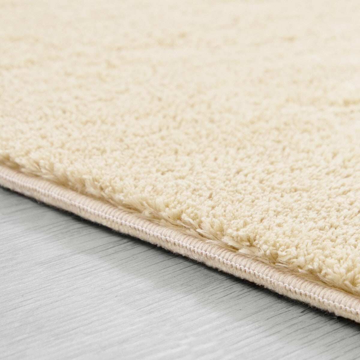 Tapis doux et lavable avec envers antidérapant, disponible en couleurs unies.