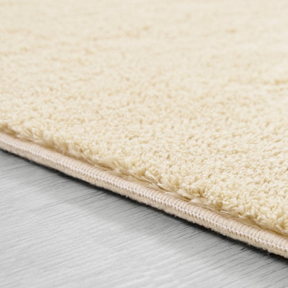Tapis doux et lavable avec envers antidérapant, disponible en couleurs unies.